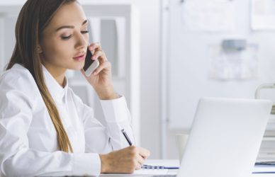 woman taking notes during a phone call